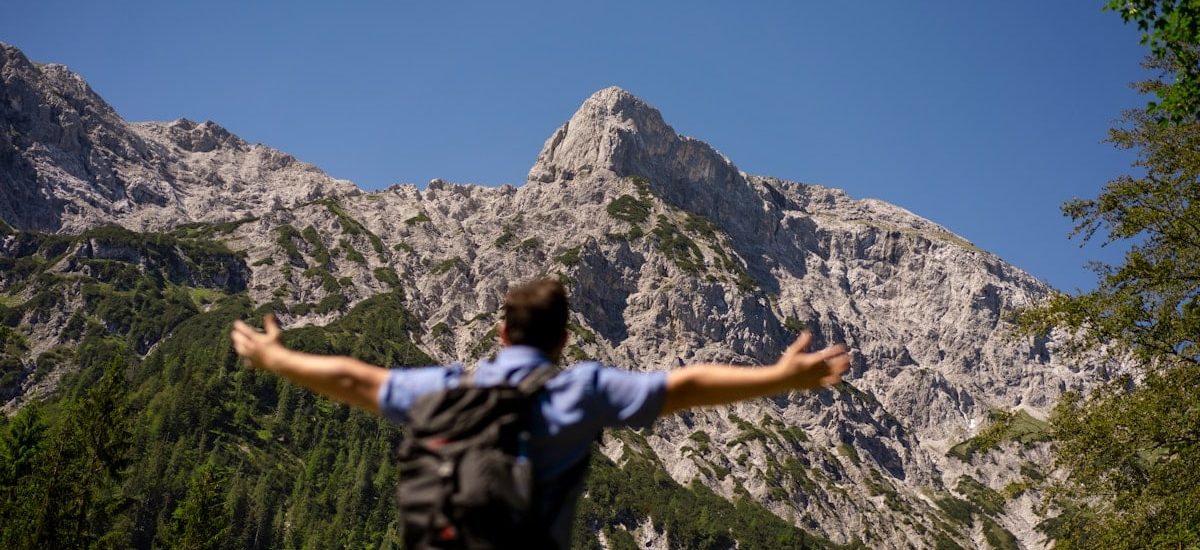 man in black and white shirt standing on rocky mountain during daytime