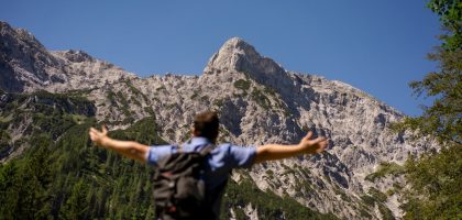 man in black and white shirt standing on rocky mountain during daytime