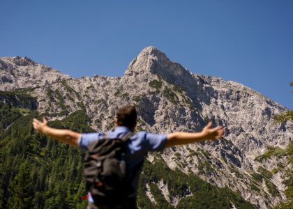 man in black and white shirt standing on rocky mountain during daytime