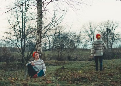 man sitting beside tree